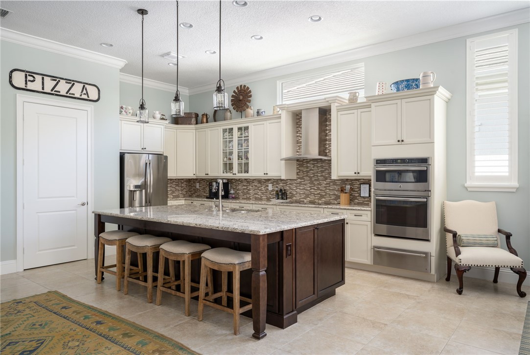 1101 River Wind Circle Vero Beach, FL 32967 - Photo 10 of 36 a kitchen with kitchen island a dining table chairs cabinets and stainless steel appliances