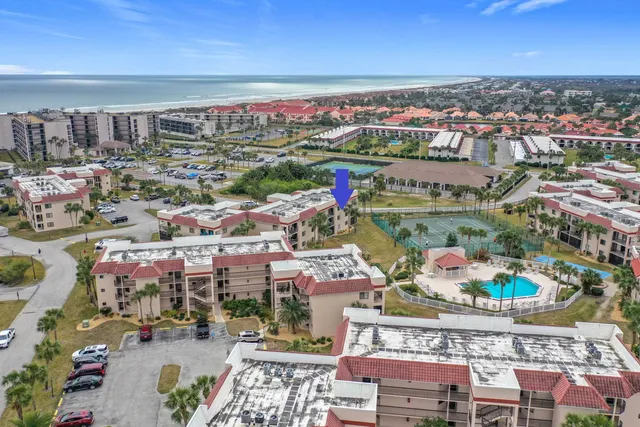 an aerial view of a city with lots of residential buildings ocean and mountain view in back