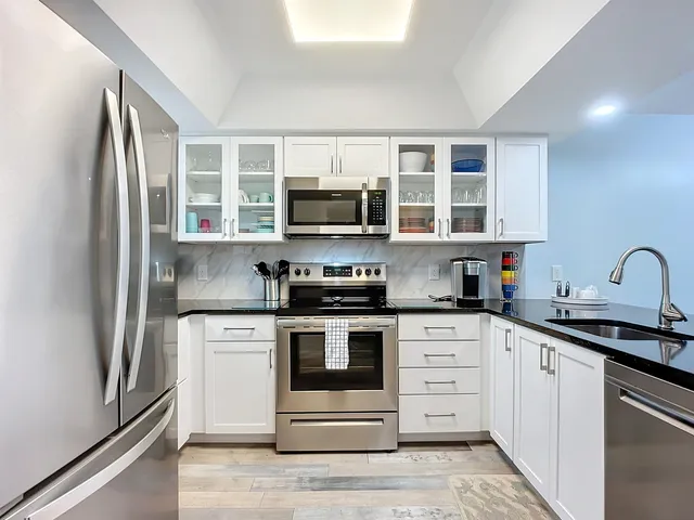 a kitchen with stainless steel appliances a refrigerator stove and microwave