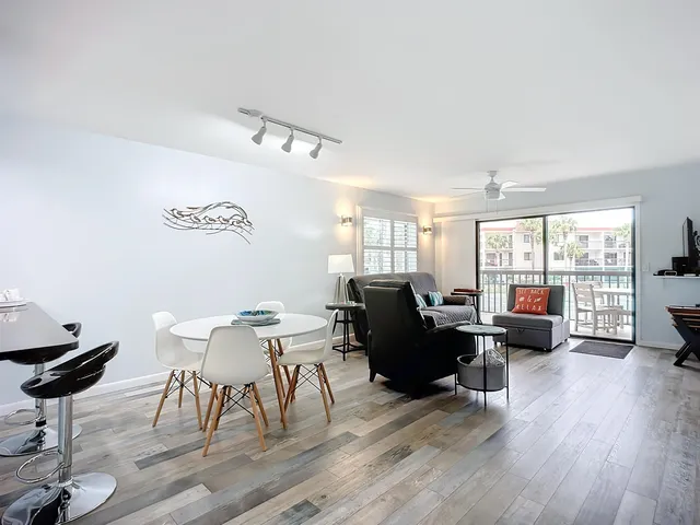 a open kitchen with stainless steel appliances granite countertop a sink a stove and white cabinets with wooden floor