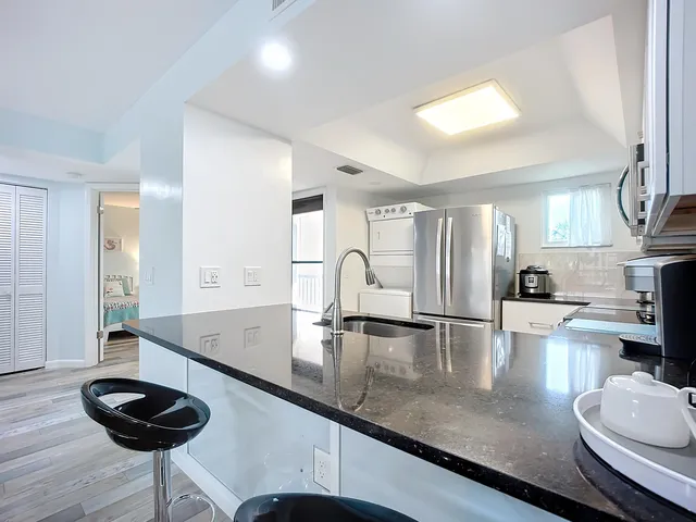 a living room with furniture kitchen view and a large window