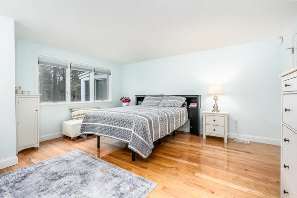 a bedroom with a bed and wooden floor