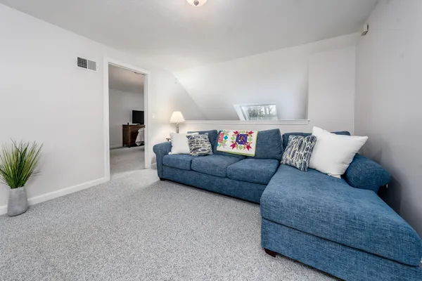 a living room with furniture and a potted plant