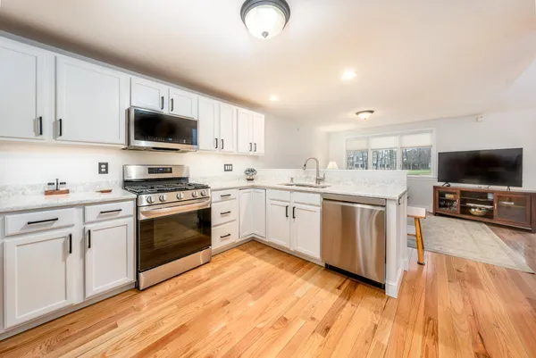 a kitchen with granite countertop a sink cabinets and stainless steel appliances