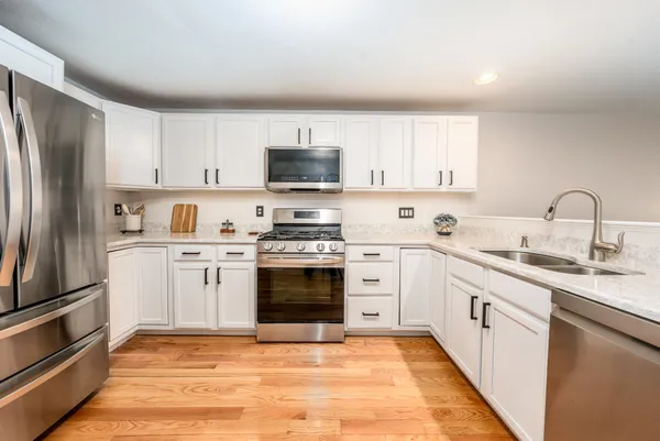 a kitchen with granite countertop a refrigerator stove and sink