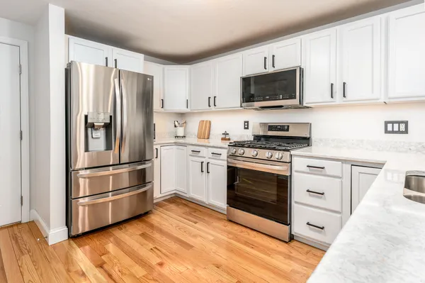 a kitchen with white cabinets and stainless steel appliances