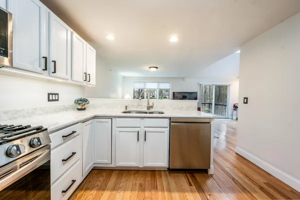 a kitchen with white cabinets and appliances