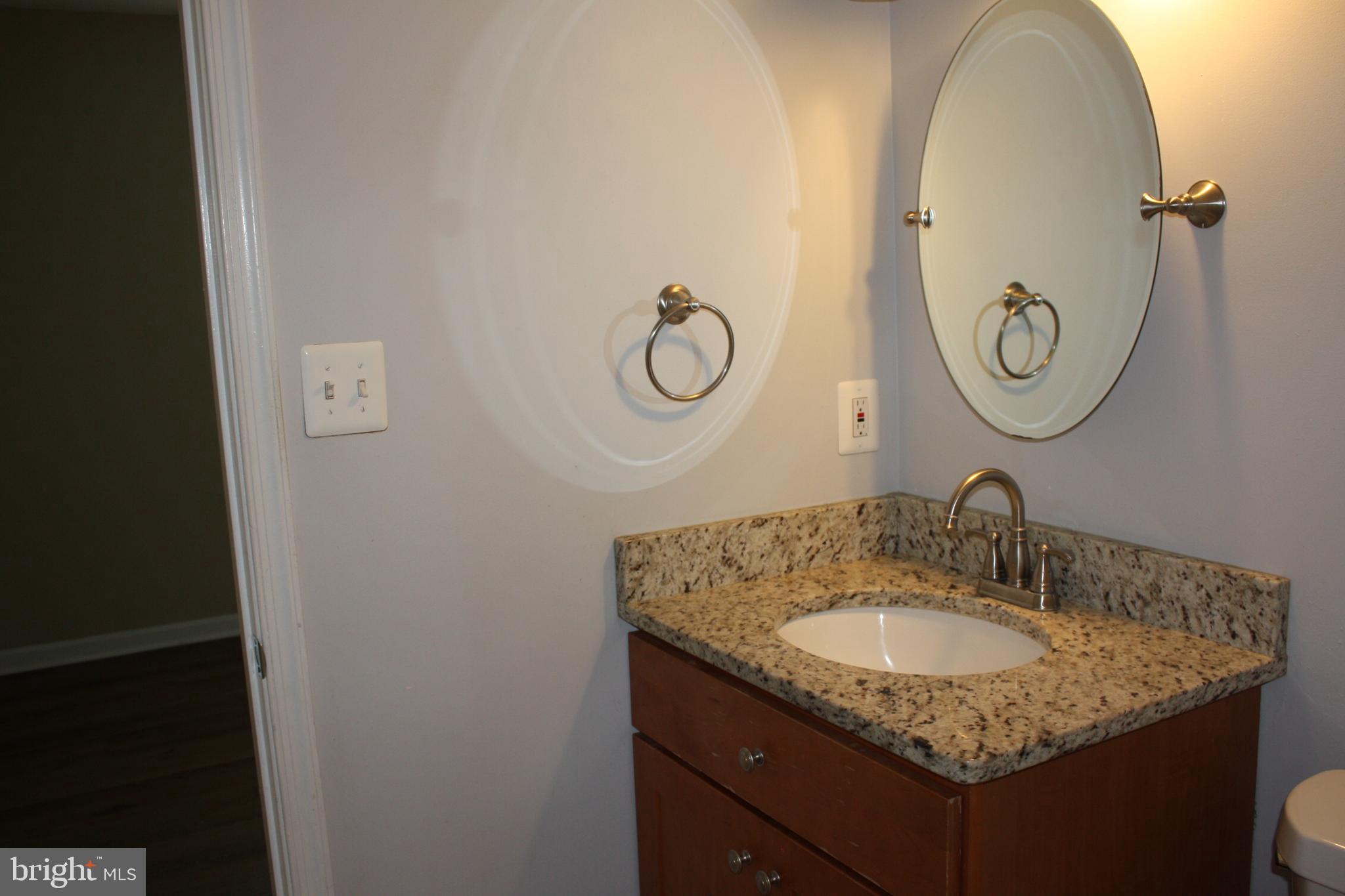 6261 Alforth Avenue Alexandria, VA 22315 - Photo 18 of 29 a bathroom with a granite countertop sink and a mirror