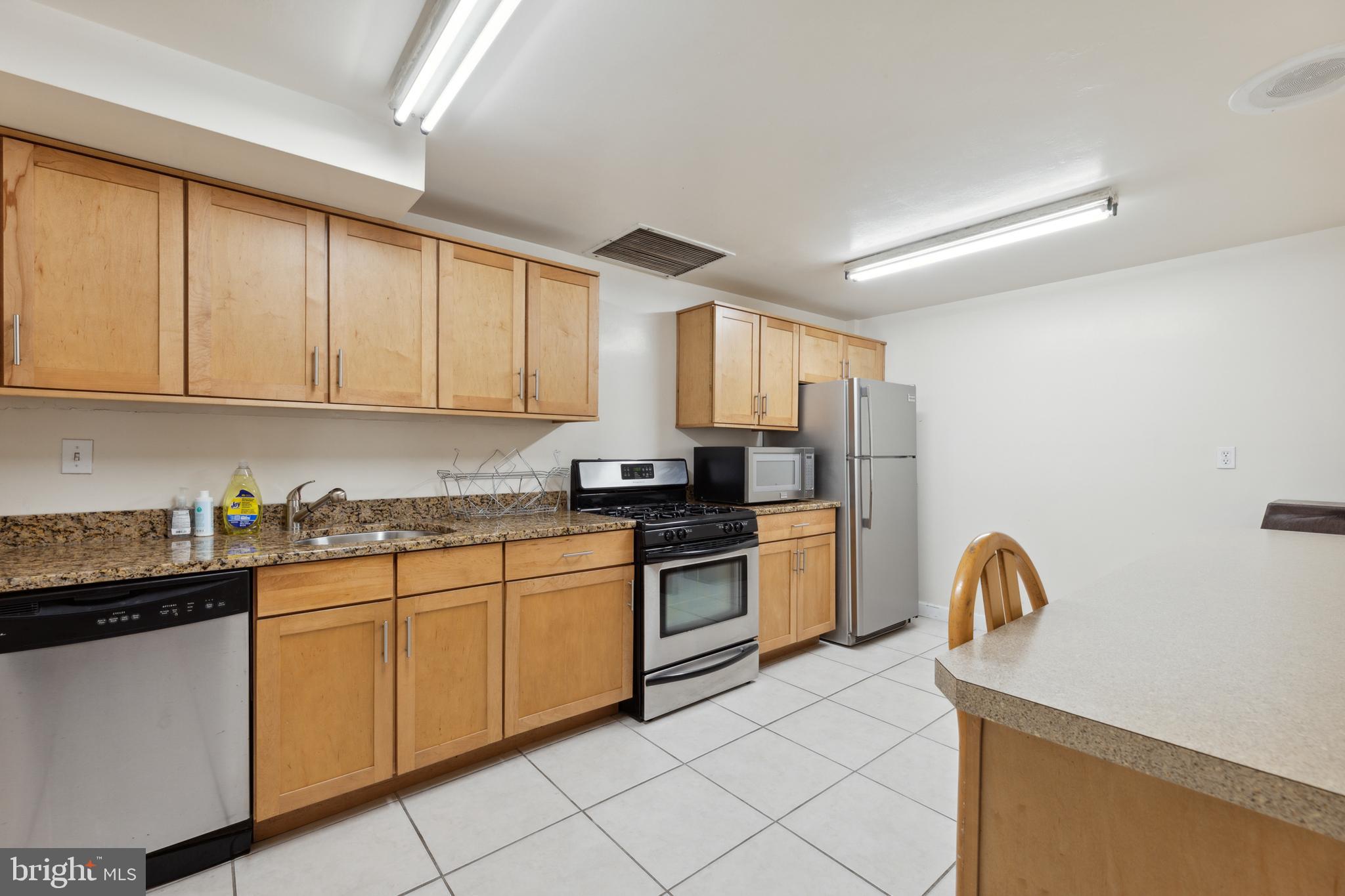 2939 Van Ness Street Northwest, Unit 1243 Washington, DC 20008 - Photo 28 of 33 a kitchen with stainless steel appliances granite countertop a stove a sink dishwasher and a refrigerator