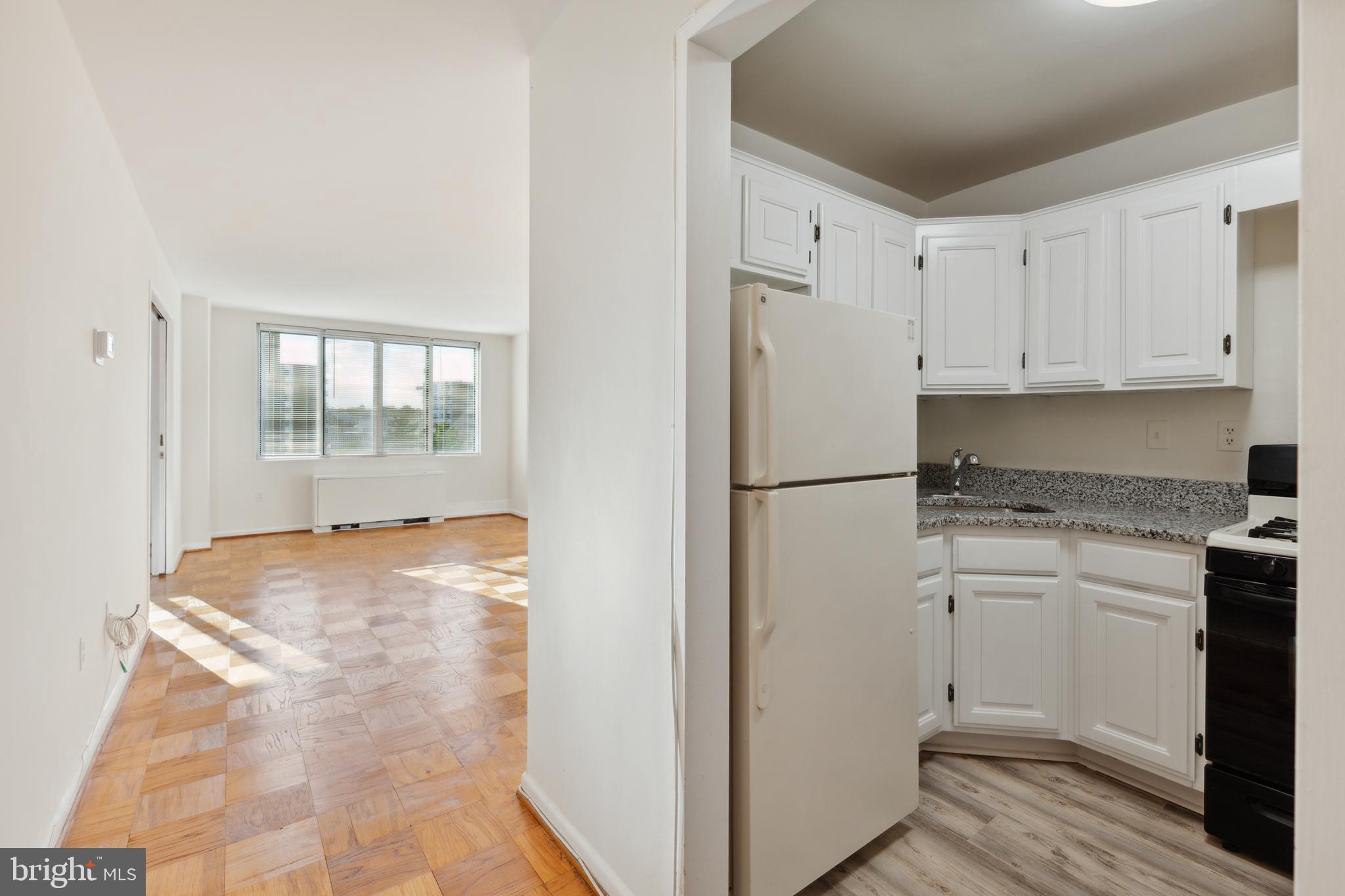 2939 Van Ness Street Northwest, Unit 1243 Washington, DC 20008 - Photo 9 of 33 a kitchen with white cabinets and refrigerator