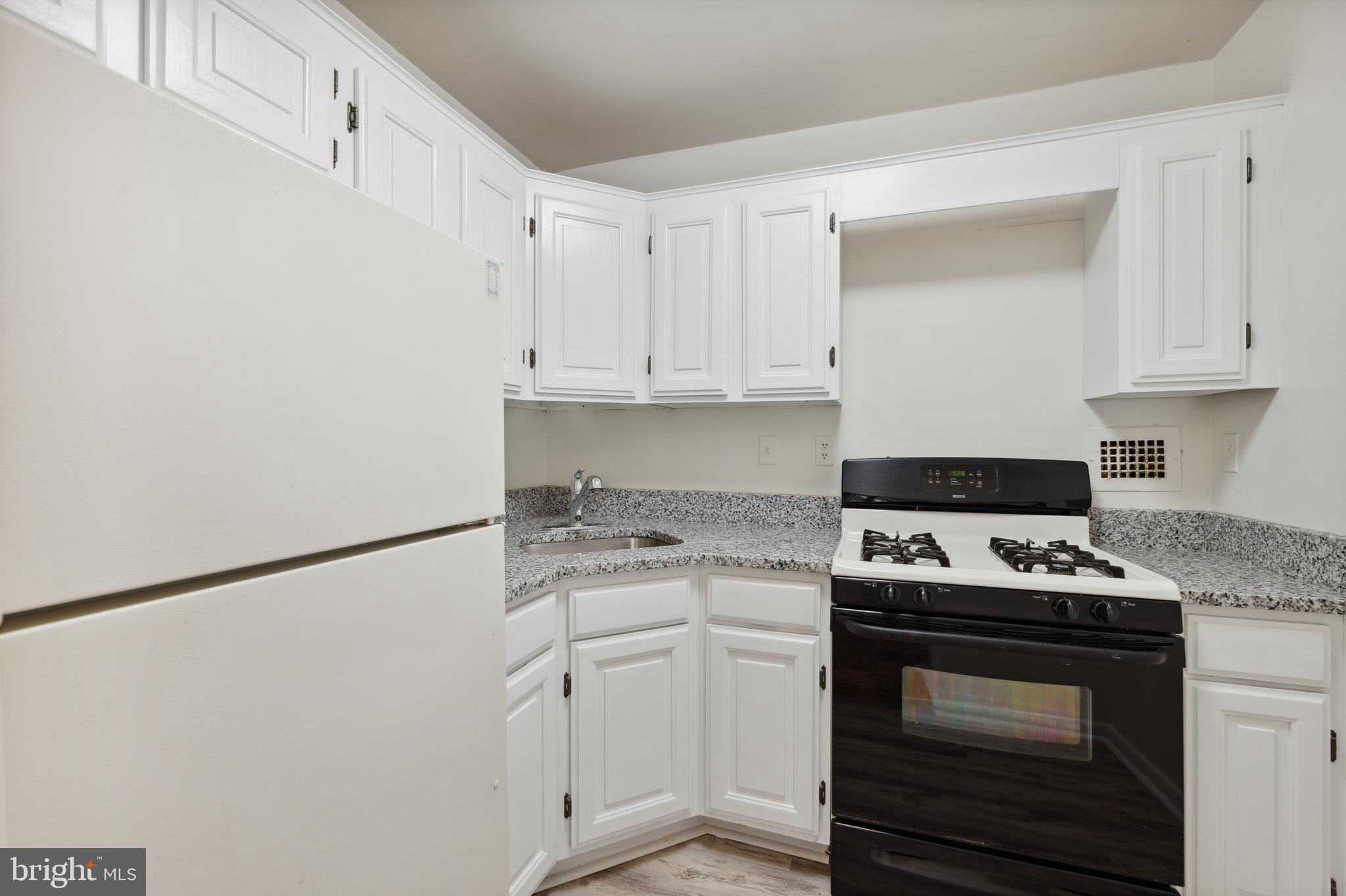 2939 Van Ness Street Northwest, Unit 1243 Washington, DC 20008 - Photo 10 of 33 a kitchen with white cabinets and white appliances