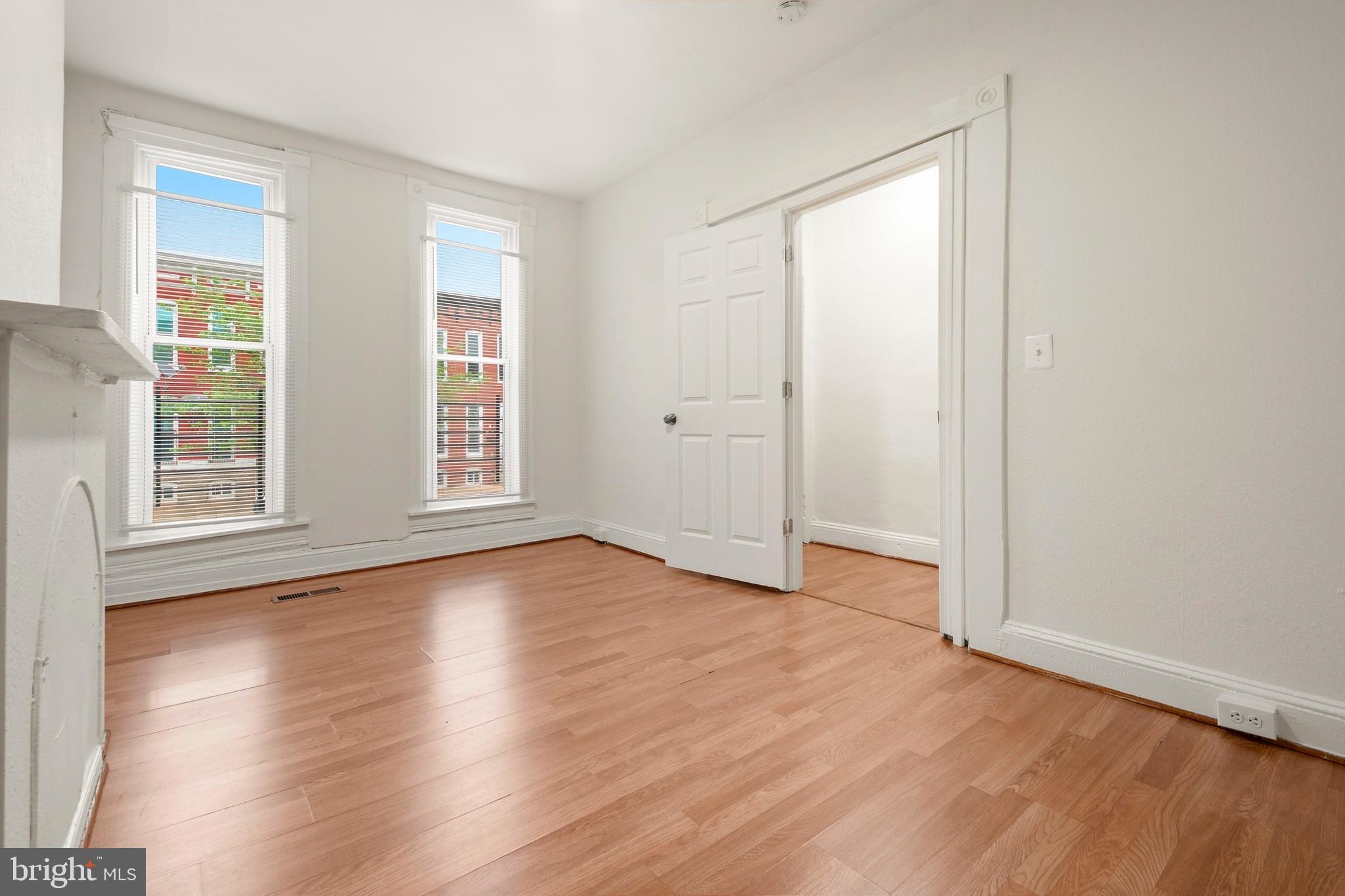 2008 Division Street Baltimore, MD 21217 - Photo 2 of 21 a view of an empty room with wooden floor and windows