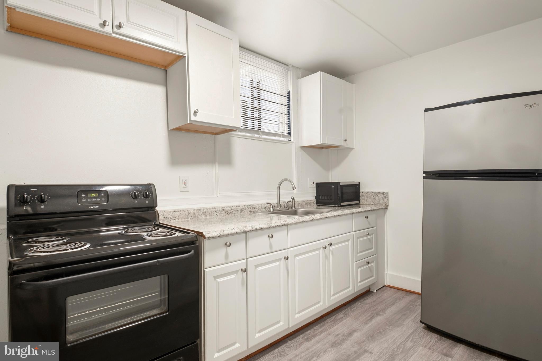 2008 Division Street Baltimore, MD 21217 - Photo 9 of 21 a kitchen with stainless steel appliances white cabinets and a stove top oven