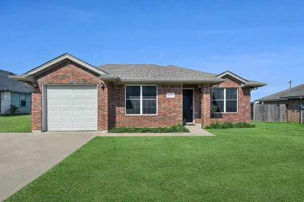a front view of a house with a garden and yard