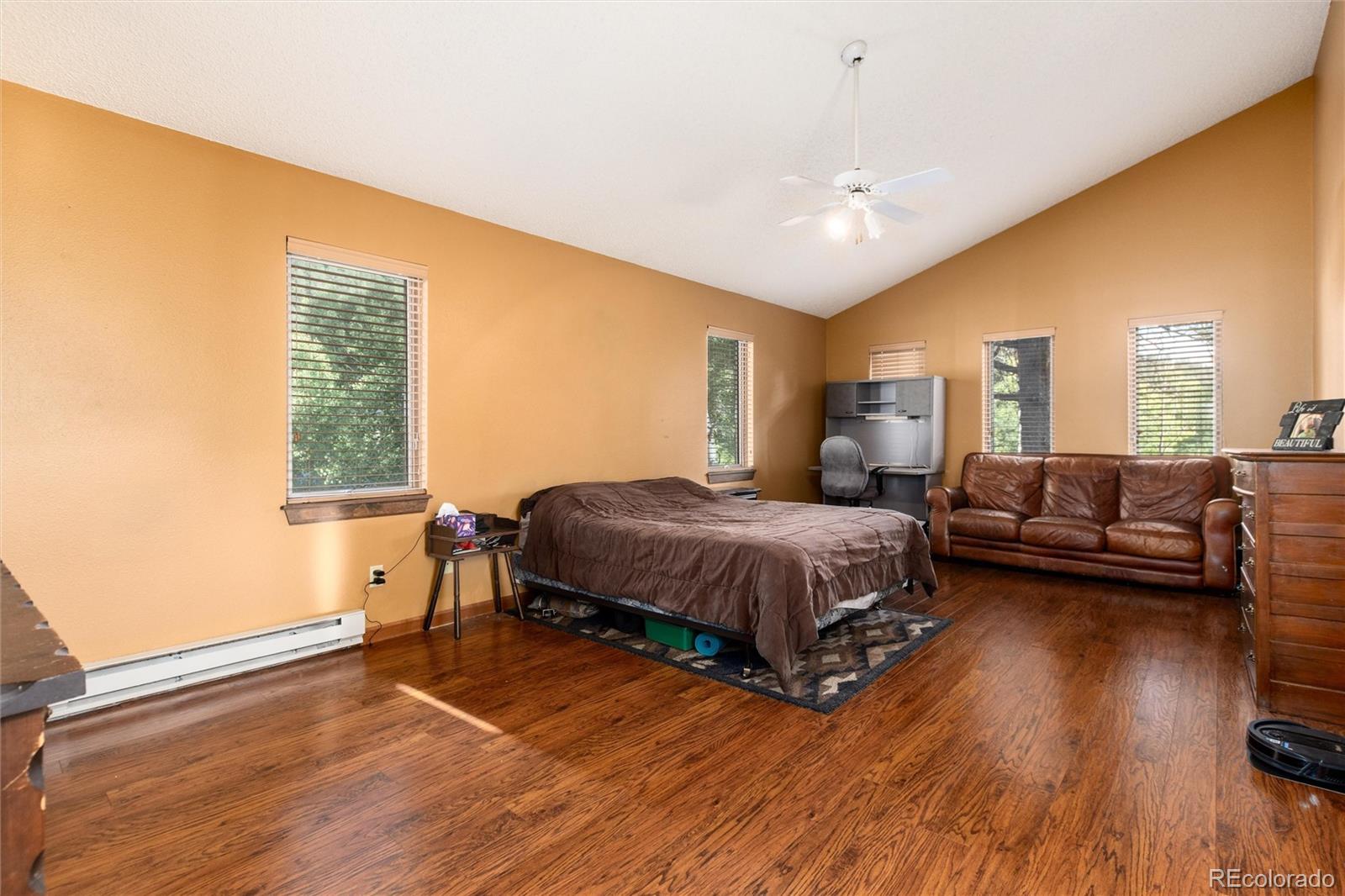 65 Silver Springs Road Bailey, CO 80421 - Photo 11 of 45 a spacious bedroom with a bed a couch and dresser in it