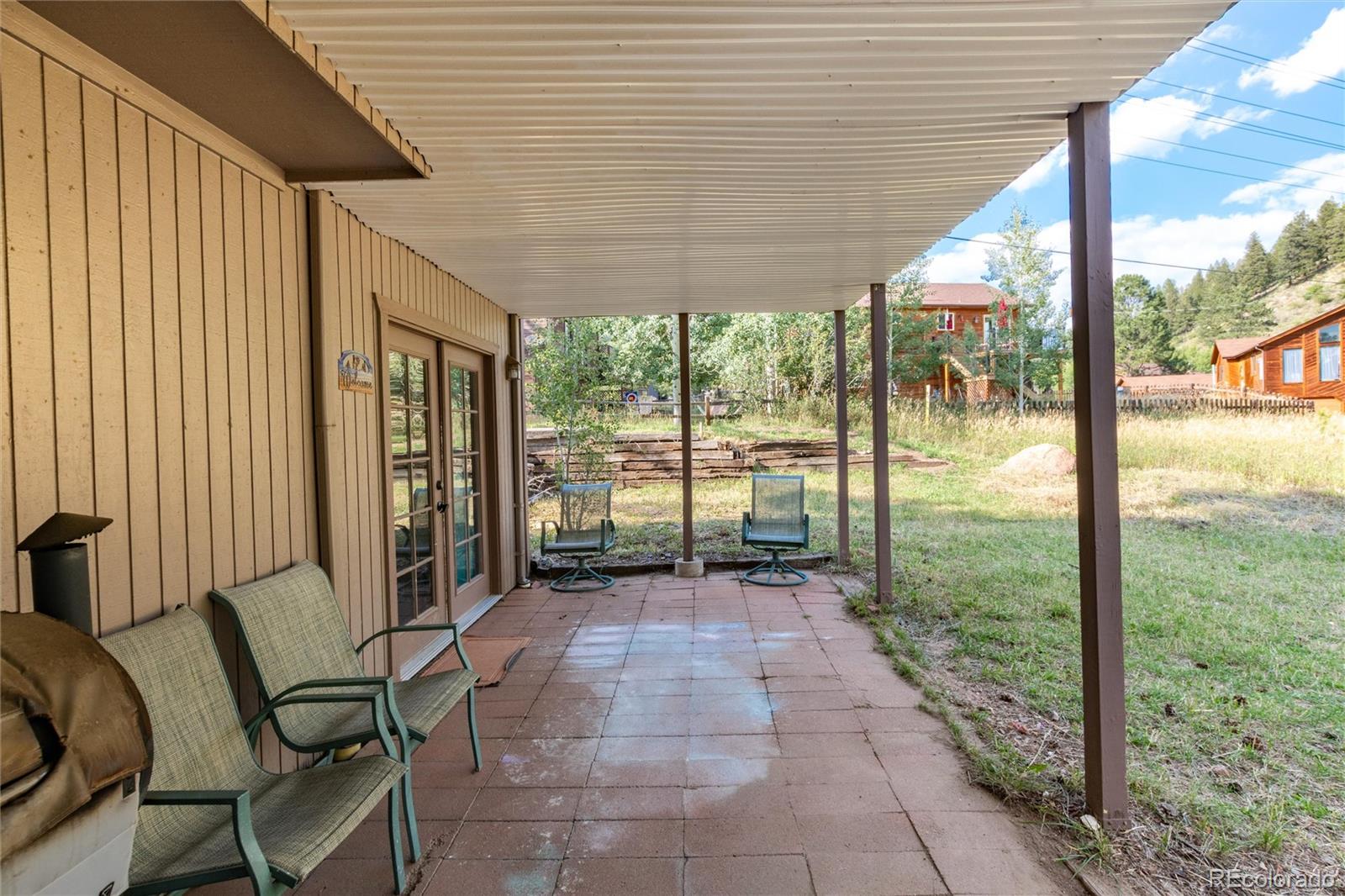 65 Silver Springs Road Bailey, CO 80421 - Photo 27 of 45 a porch with a table chairs and wooden floor