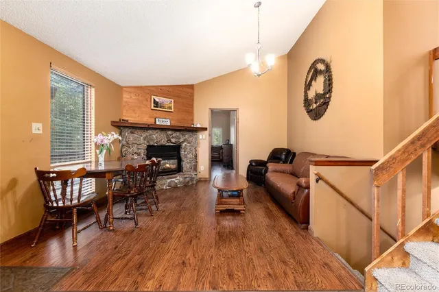 a living room with furniture a fireplace and a large window