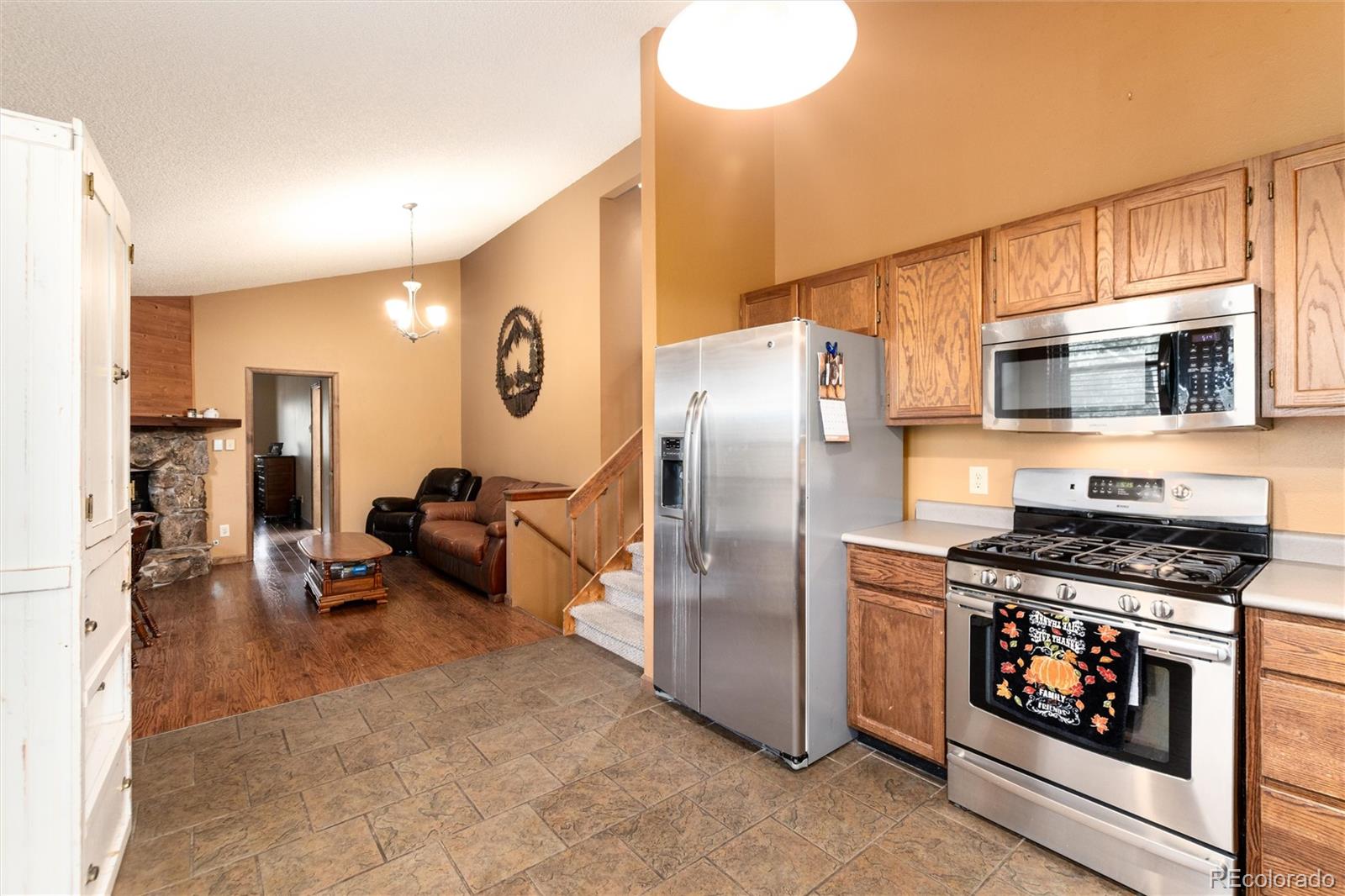 65 Silver Springs Road Bailey, CO 80421 - Photo 8 of 45 a kitchen with stainless steel appliances a stove a microwave and a refrigerator