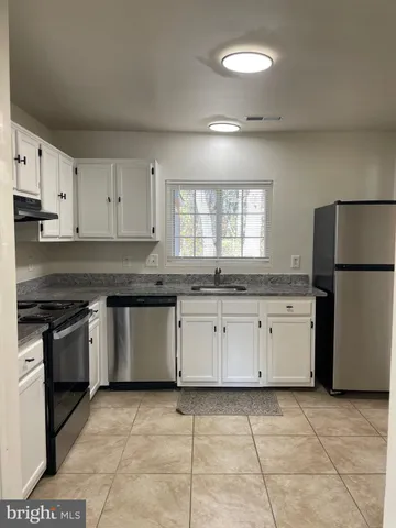 a kitchen with cabinets appliances and a window