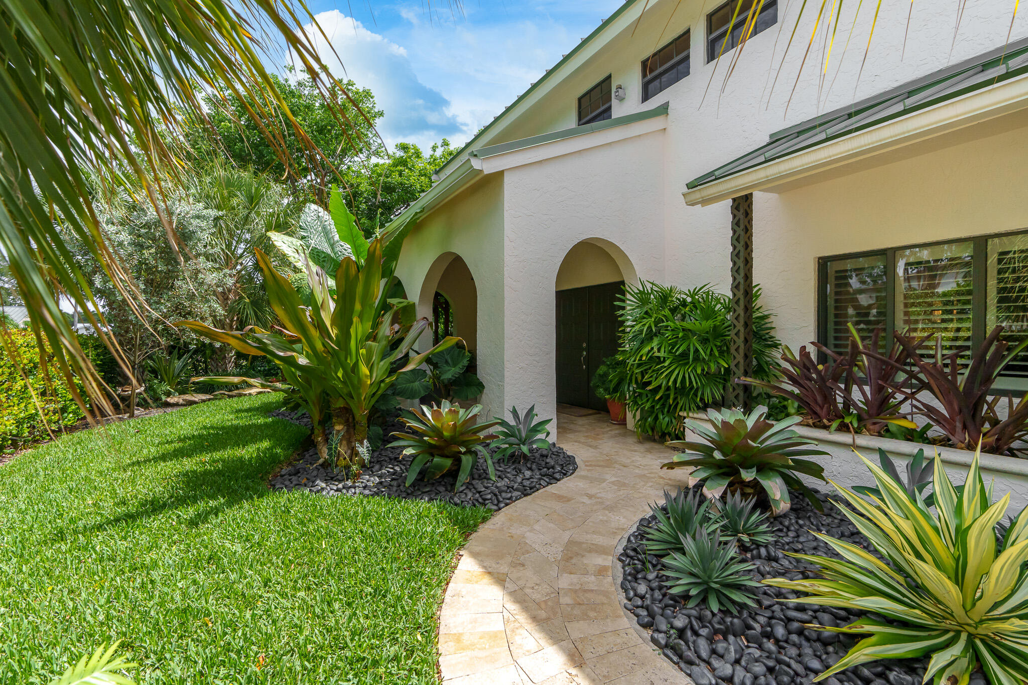 23397 Lago Mar Circle Boca Raton, FL 33433 - Photo 4 of 70 a front view of yellow house with a garden