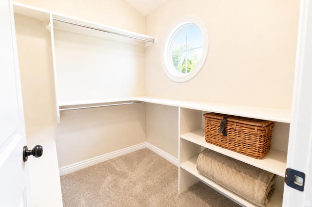 896 Cres Drive South Mapleton, UT 84664 - Photo 14 of 32 Built-in shelving and hanging rods with a circular window, neutral-toned walls, and carpet flooring