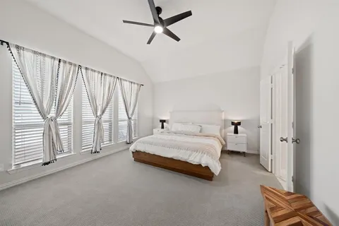 a spacious bedroom with a bed and a window