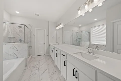 a spacious bathroom with double vanity a sink a mirror a vanity and bathtub