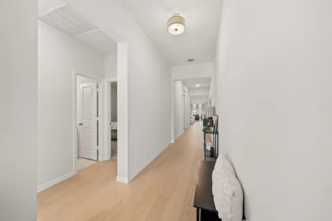 a view of a hallway with closet and wooden floor
