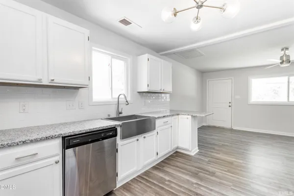a kitchen with granite countertop white cabinets and a sink