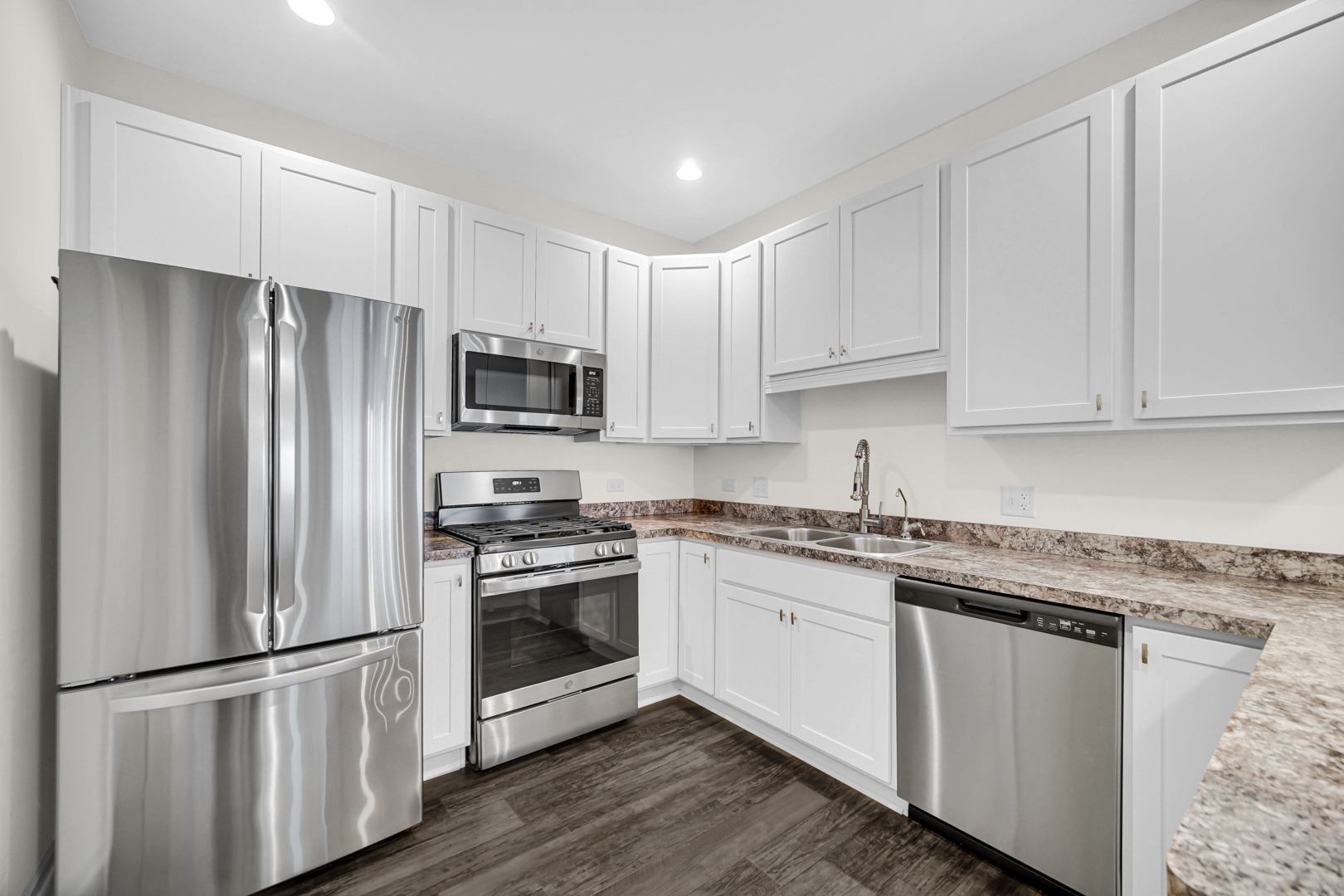 925 Baltimore Street McHenry, IL 60050 - Photo 6 of 27 a kitchen with stainless steel appliances granite countertop a refrigerator stove a sink and white cabinets
