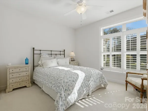 a bedroom with a bed a couch and large window