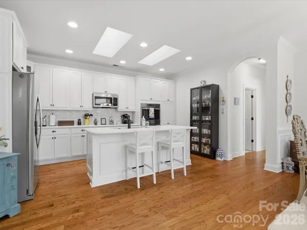 a kitchen with white cabinets and refrigerator