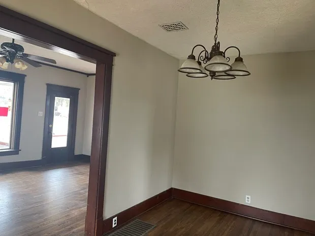 a view of a room with wooden floor and windows