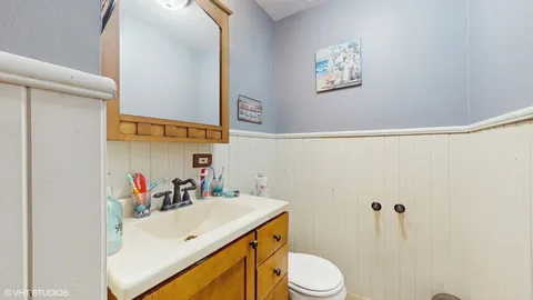 a bathroom with a sink vanity mirror and toilet