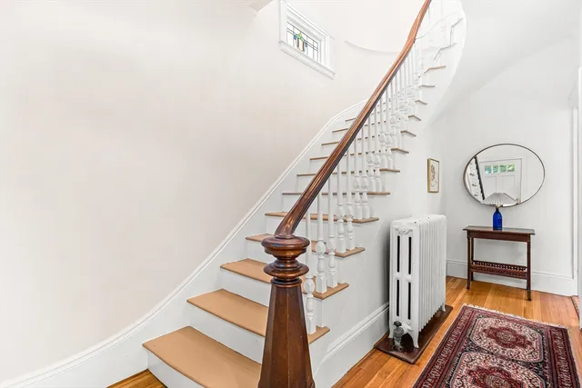 a view of staircase with a rug and a chandelier