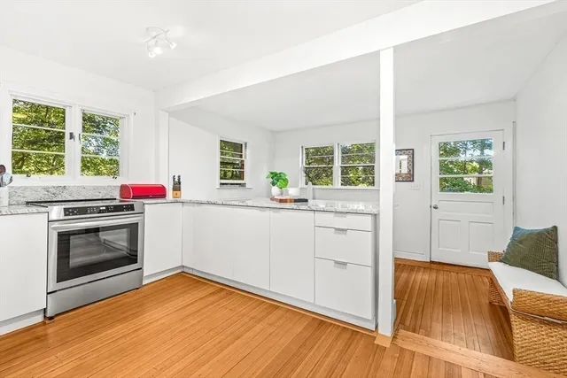 a kitchen with a stove and wooden floor