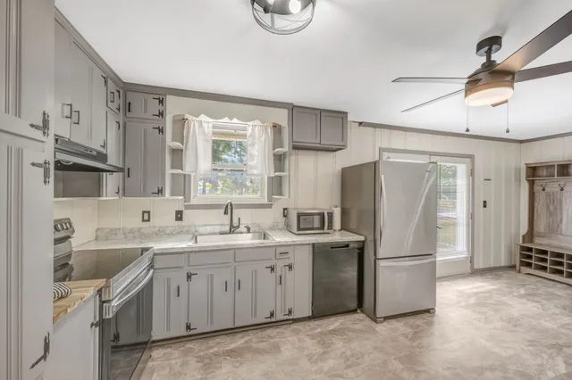 a kitchen with a sink appliances and cabinets