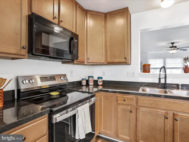a kitchen with granite countertop a stove microwave and sink