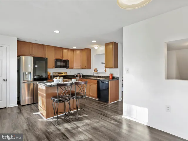a kitchen with kitchen island granite countertop wooden floors and stainless steel appliances