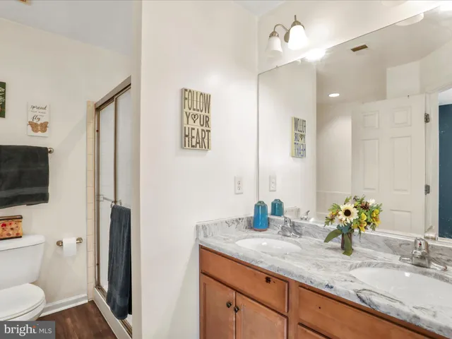 a bathroom with a granite countertop sink a toilet and a mirror