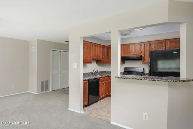 a kitchen with stainless steel appliances kitchen island granite countertop a stove a sink and a microwave