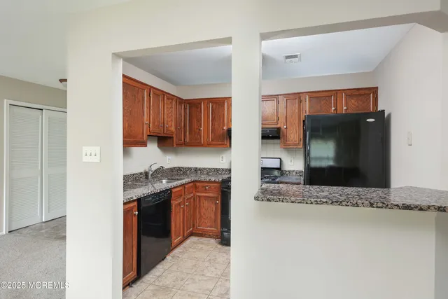 a kitchen with stainless steel appliances granite countertop a refrigerator stove and cabinets