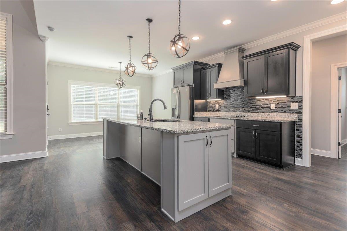 3328 Straw Bridge Road Olive Branch, MS 38654 - Photo 15 of 28 Kitchen featuring dark wood-finish flooring, a central island with granite countertop, dark cabinetry, stainless steel appliances, and orb pendant lighting