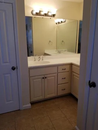 a bathroom with a granite countertop sink and a mirror