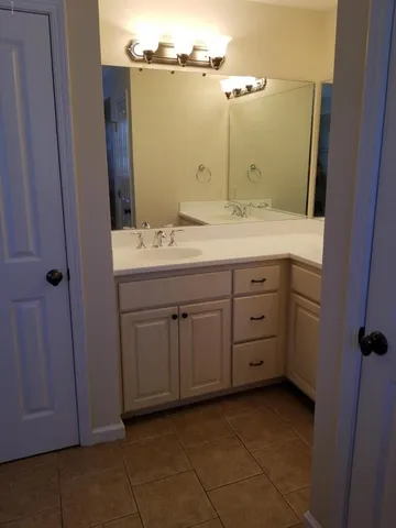a bathroom with a granite countertop sink and a mirror