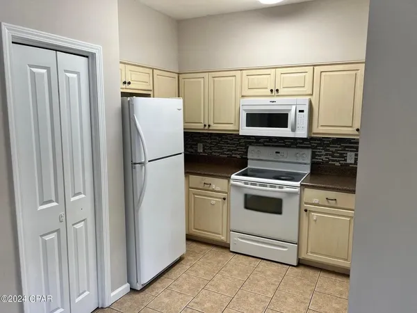 a kitchen with white cabinets and white appliances