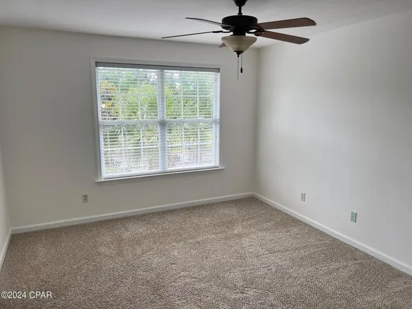 an empty room with a window and a fan