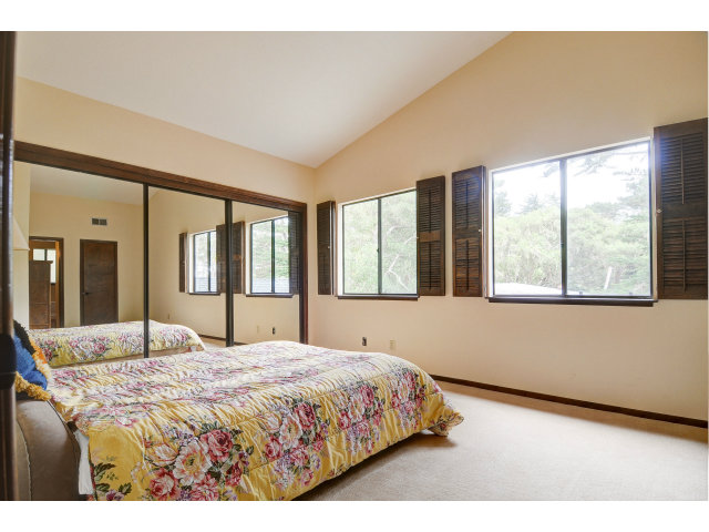 3075 El Toro Road Pebble Beach, CA 93953 - Photo 18 of 25 a bedroom with a large bed and a large window