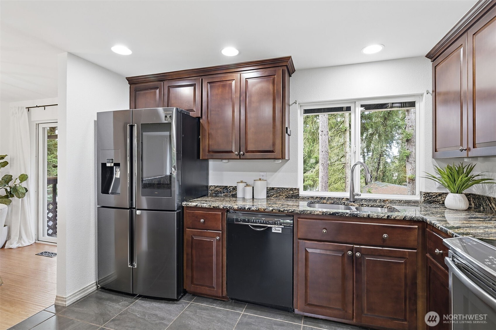 927 217th Street Southwest Bothell, WA 98021 - Photo 11 of 33 a kitchen with granite countertop stainless steel appliances a refrigerator cabinets a sink and a window