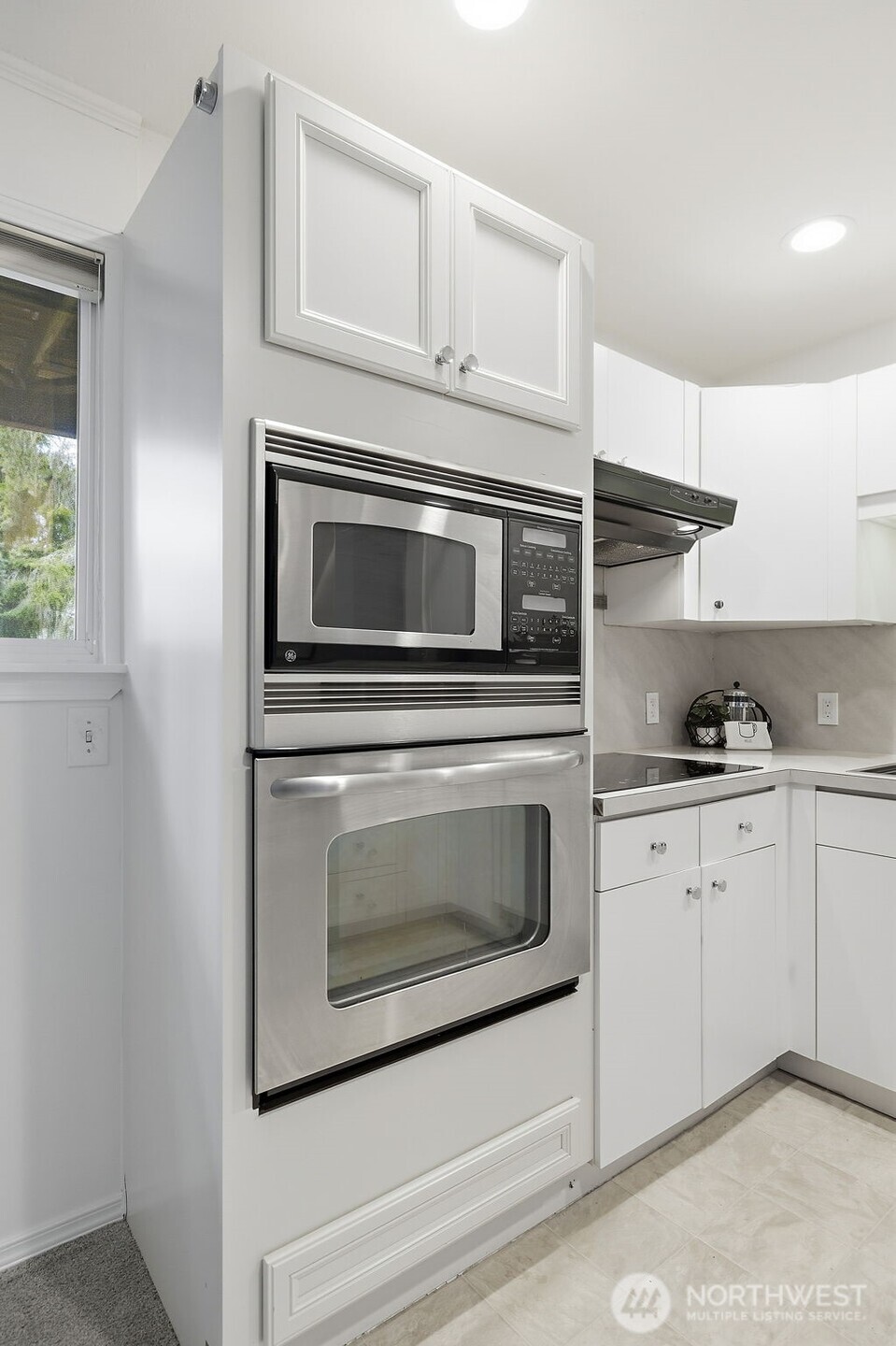 927 217th Street Southwest Bothell, WA 98021 - Photo 25 of 33 a kitchen with granite countertop white cabinets stainless steel appliances and a window